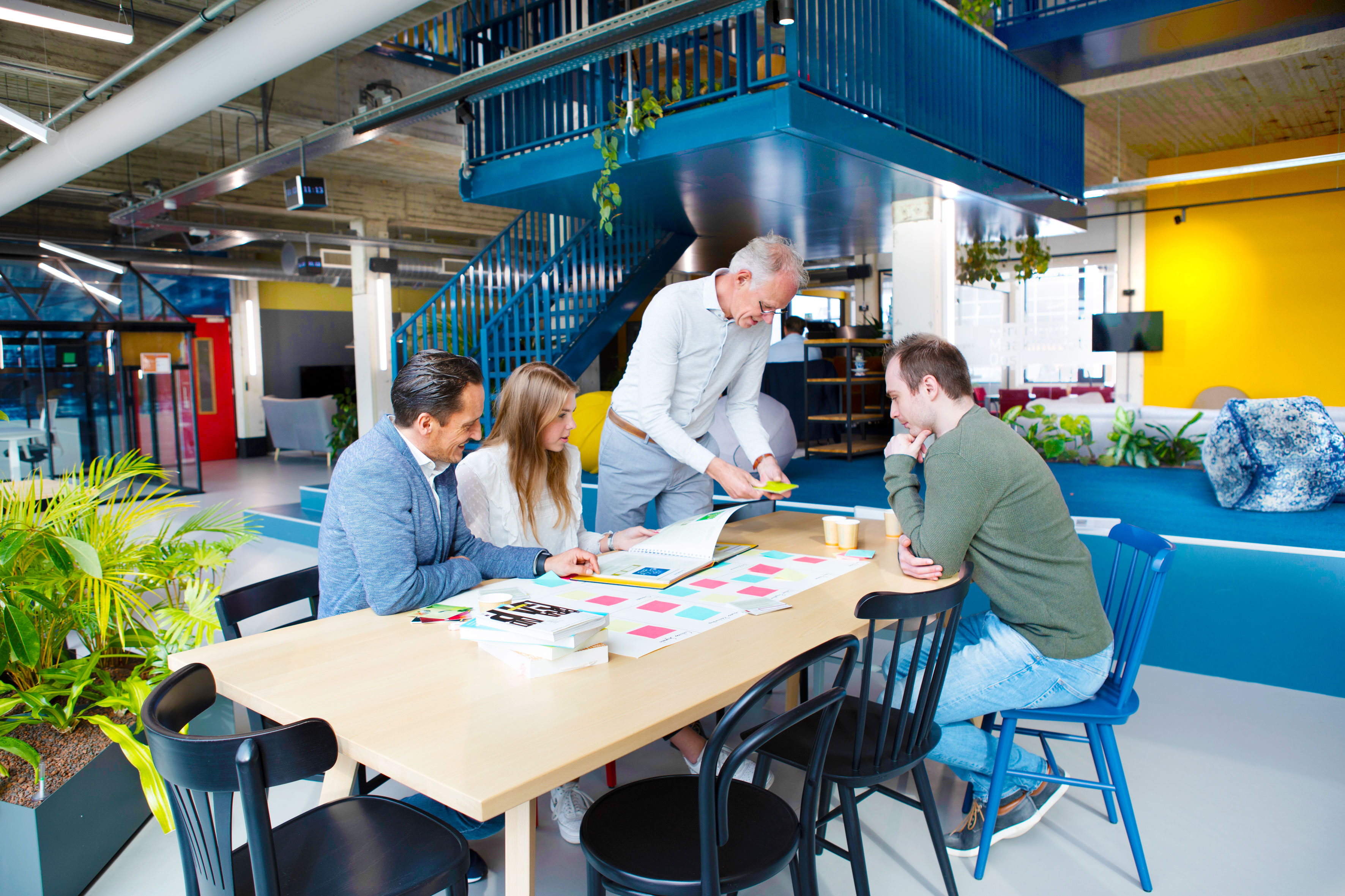 een groep mensen die rond een lijst zitten