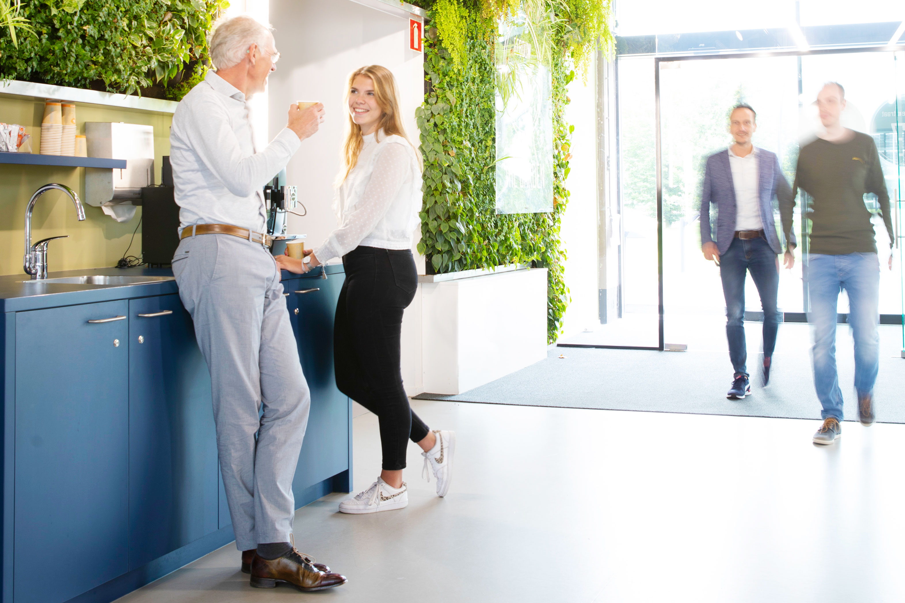 een vrouw en een man die zich in een ruimte met andere mensen bevinden