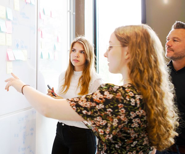 een persoon die naar een whiteboard wijst