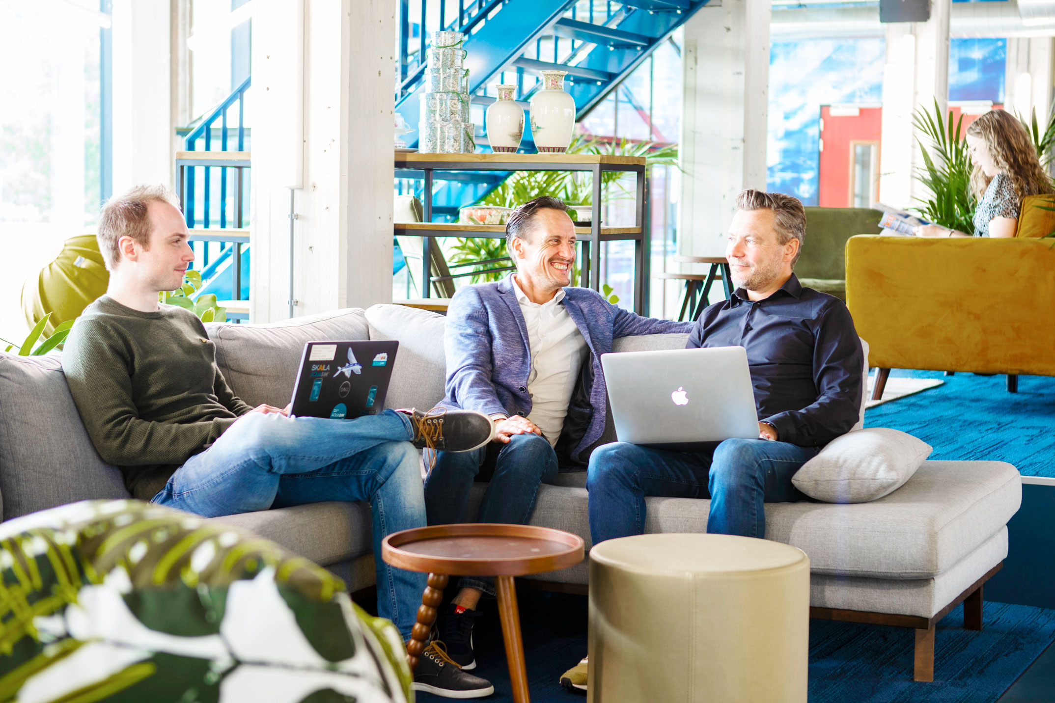 een groep mensen die op een laag met laptops zitten