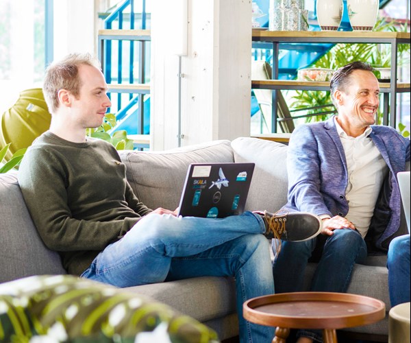 een groep mensen die op een laag met laptops zitten